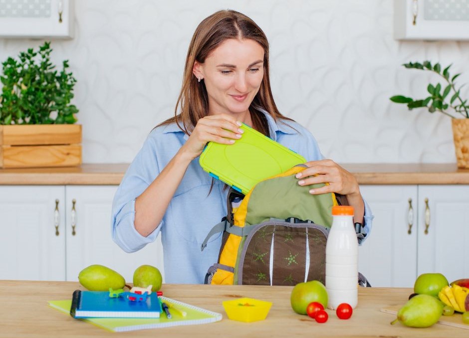 Immagine di donna che mette una lunch box nello zaino